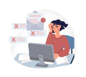 Job applicant looking stressed at computer after receiving resume rejection notifications
